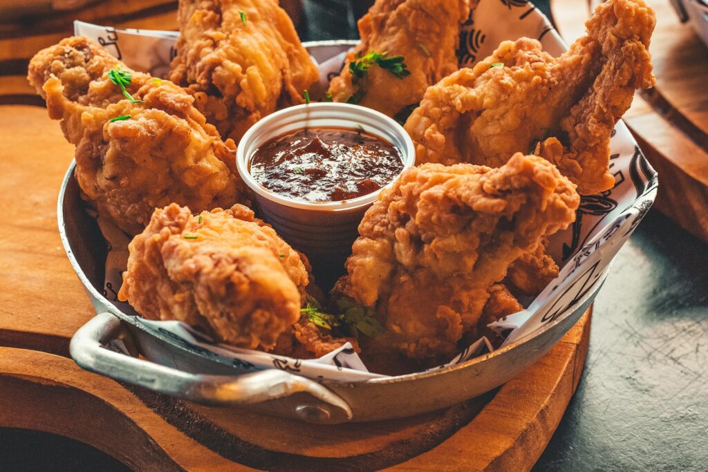 A tray with fried chicken and a small cup of ketchup sauce