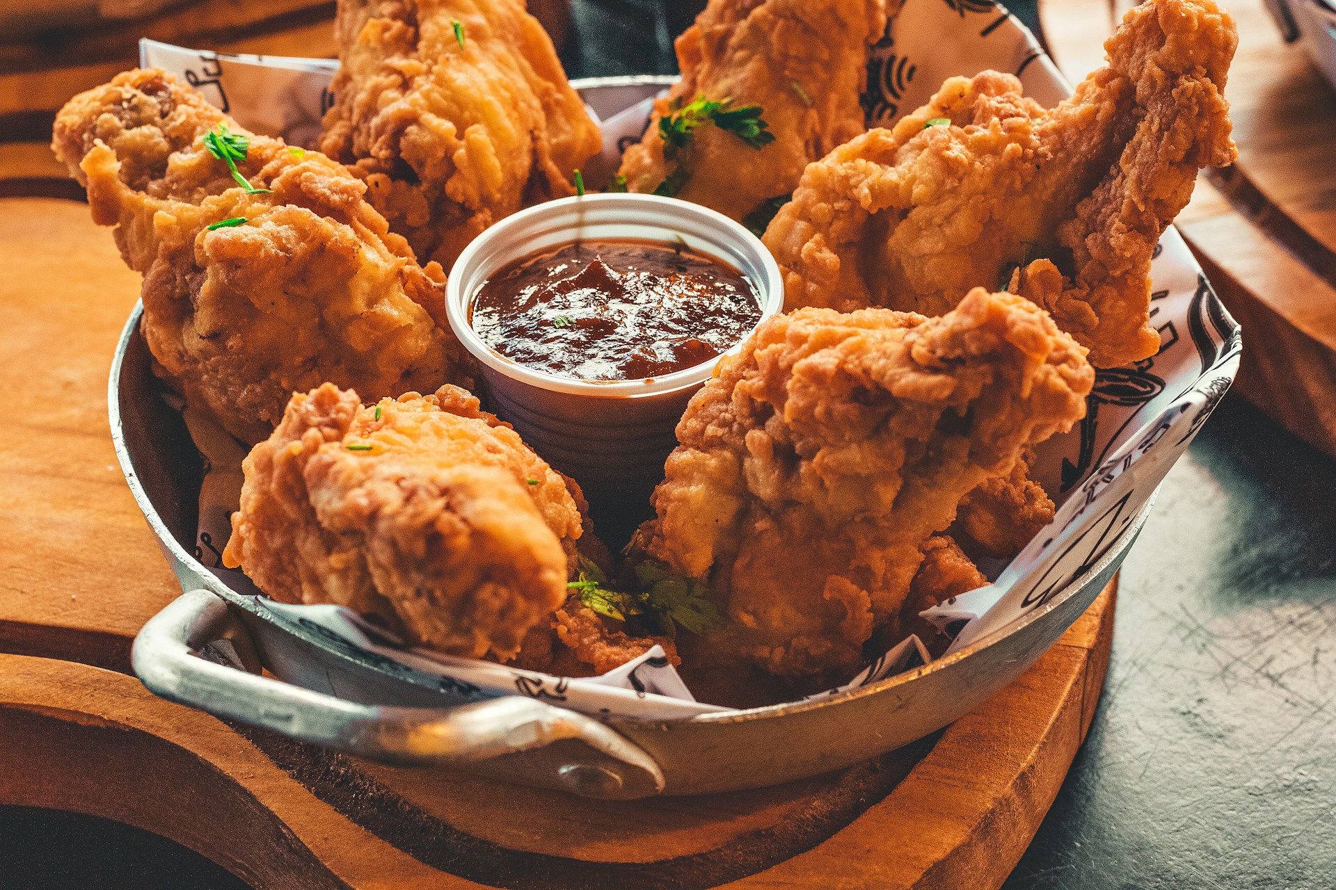 A tray with fried chicken and a small cup of ketchup sauce